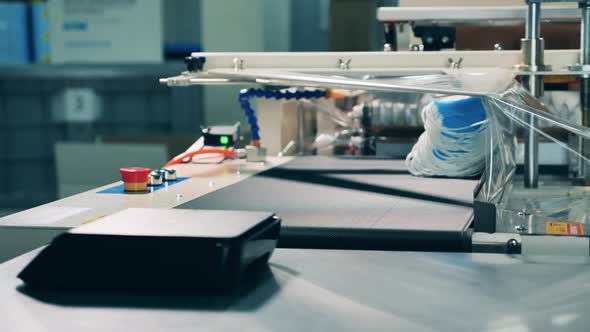 Medical Professional Loading Face Masks Into a Packing Machine alt