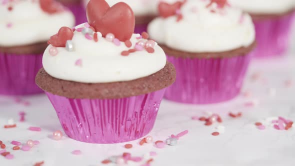Red velvet cupcakes with cream cheese frosting and decorates with heart and kiss shaped red chocolat alt