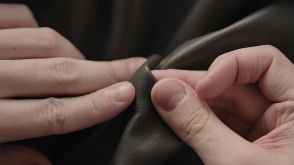 Slow Motion Man Hand Inspectingsoft Leather Jacket with Sun Shining From a Window alt