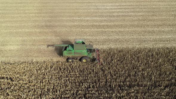 Aerial View of a Harvester Harvesting Corn in the Field alt