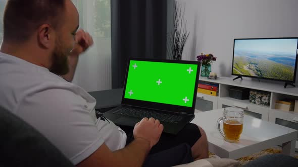 Man Using Laptop with Greenscreen and Chroma Key. alt