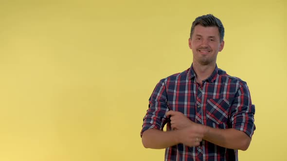 Cheerful Young Man Getting a Tip From Somebody and Showing Forefinger To the Side. alt