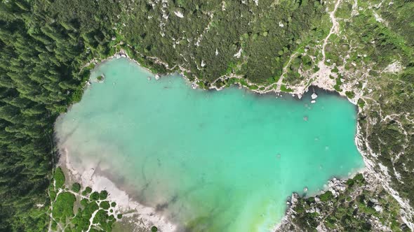Hikers and travelers enjoying the turquoise Lago di Sorapiss (mountain lake) alt
