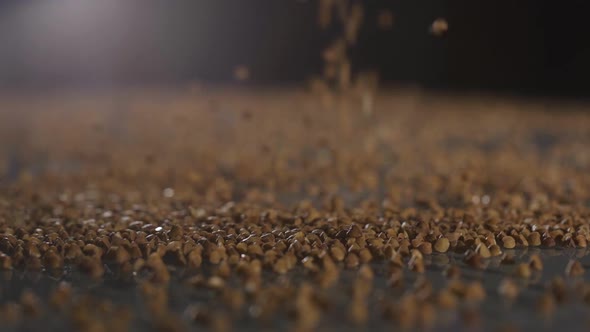Buckwheat Falls on a Glass Table. Slow Motion Side View.