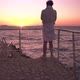 Back View of Man Standing on Observation Point Looking at Sunset Over Ocean and Talking on Mobile - VideoHive Item for Sale