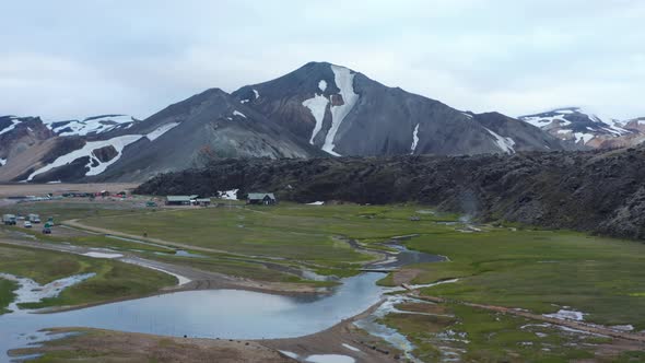 Mountains with Snow and Camping Site in Valley alt
