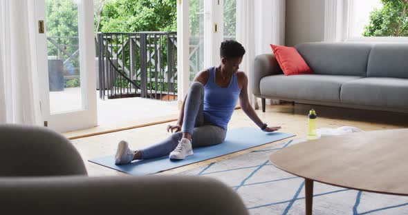 African american woman performing stretching exercise at home alt