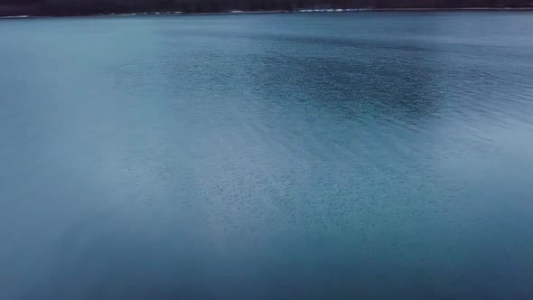 The drone turns fast around over a lake in Switzerland. alt