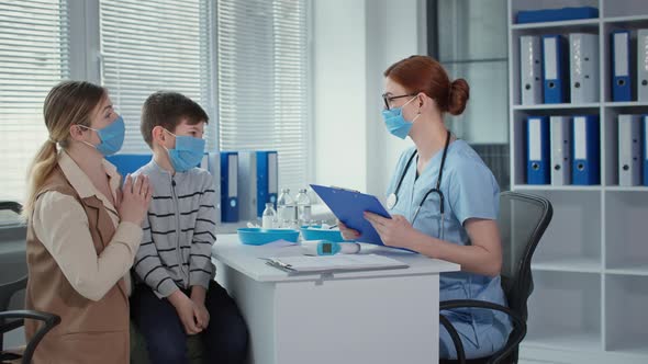 Consultation with a Doctor During Pandemic Female Physician in Medical Mask and Glasses is Talking