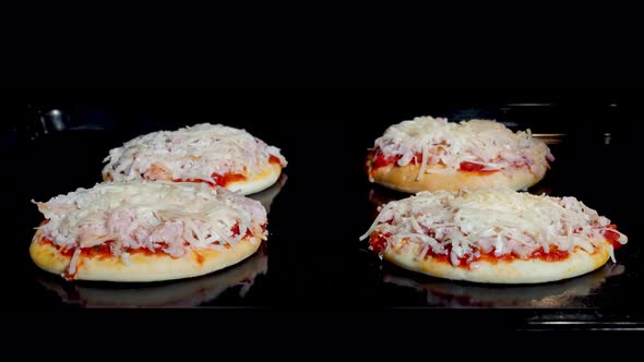 Timelapse  Four Mini Pizzas Baking in Electric Oven at Home Front View