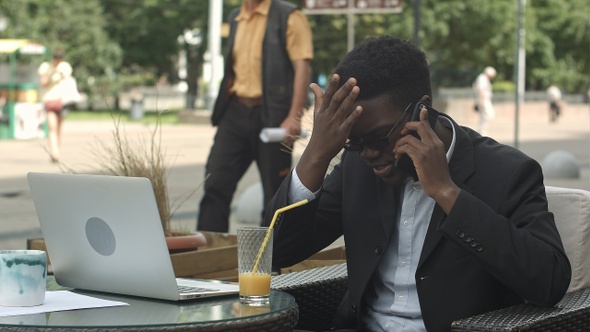 Afro-American Businessman Negotiating by Phone Defending