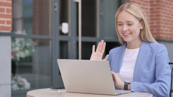 Online Video Chat on Laptop by Young Businesswoman Sitting Outdoor alt