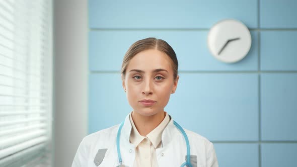 Professional blonde young woman doctor in white coat alt