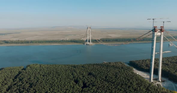 Towers And Main Cables Of Braila Bridge Under Construction Over Danube River In Romania. - aerial alt