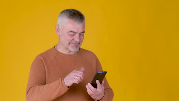 Handsome adult man uses smartphone texting messages in social media
