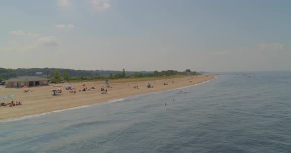 Flying Over Water and Towards Sandy Beach Shore on a Sunny Day in Long Island alt