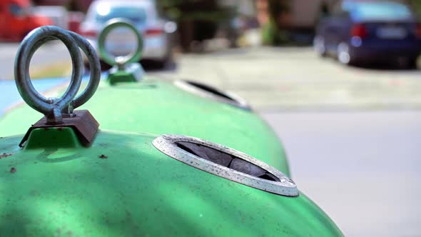 Man throwing away empty, glass bottle in recycling bin  alt