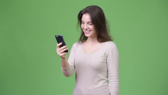 Young Beautiful Woman Using Phone Against Green Background alt