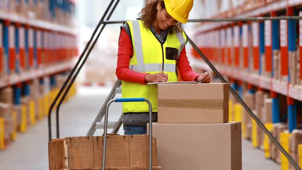 Female warehouse worker checking stock for shipping alt