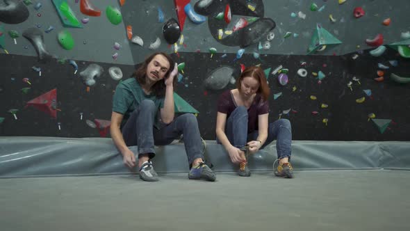 Guy and a Girl Sit and Chat Near the Climbing Wall Put on Their Shoes and Sew the Laces on Their alt