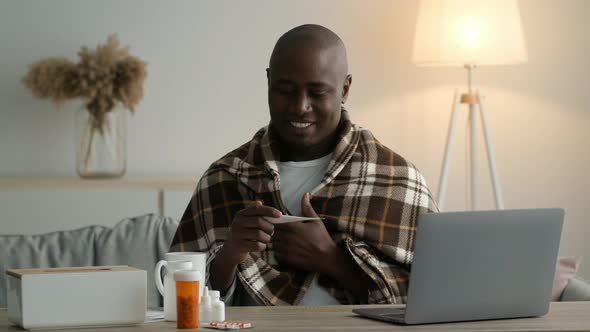Happy African Man Holding Thermometer Measuring Temperature After Recovery Indoor alt