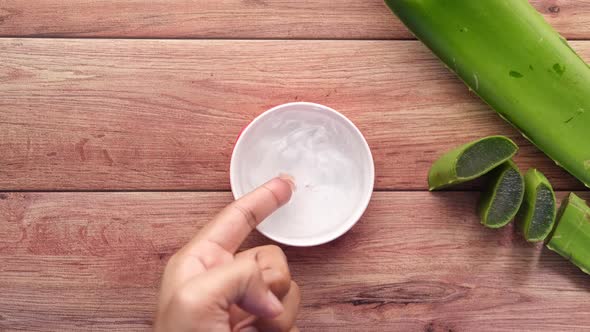 Fresh Aloe Vera Sliced and Liquid Gel in Plastic Container on White Background alt