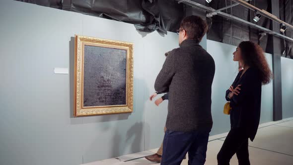 People Are Viewing Picture in Gallery Worker Is Carrying Off It From Hall alt