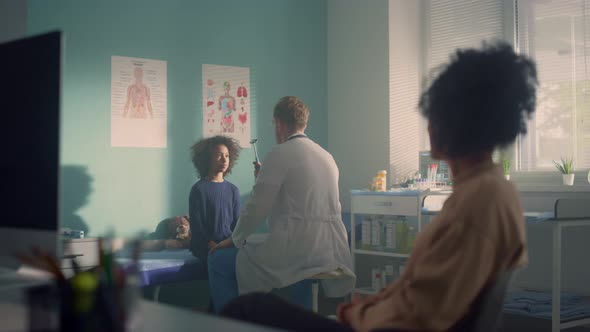 Doctor Checking Girl Visual Reflex in Office alt