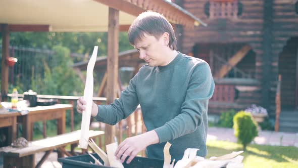 Travelling Young Guy is Standing Near the Barbecue in Which Coals are Smoking 1 alt