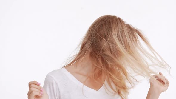 Young Beautiful Caucasian Blonde Girl Waving Hair and Head Smiling on White Background in Slowmotion alt