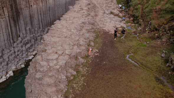 Bird's Eye View Shot of Tourists by the Studlagil Canyon - River in Background alt
