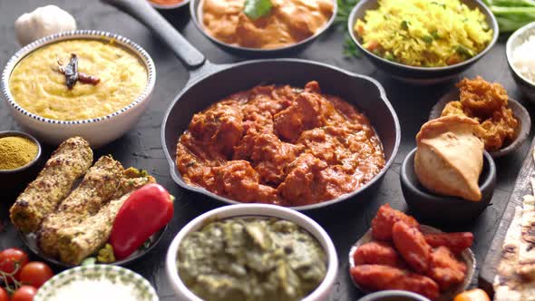 Various Indian Dishes on a Table. Spicy Chicken Tikka Masala in Iron Pan alt