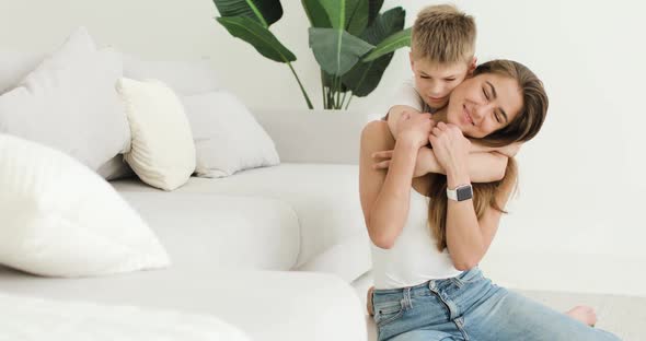 Young Mother and Little Son Have Fun at Home in the Living Room