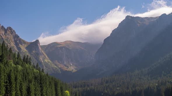 Time Lapse Shot Mountains Peaks Mountain Range Covered with Rolling Clouds in Blue Sky Sun Light alt