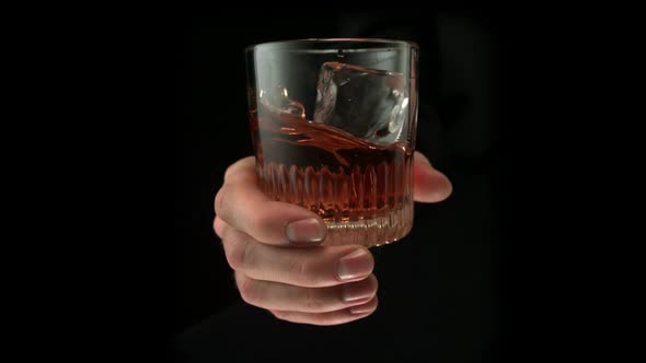 Hand stirring a glass of drink, Slow Motion alt