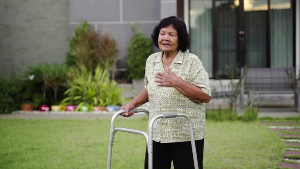 tired senior woman having heart problem after walking with walker at home