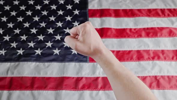Rised Caucasian Fist on Blurry US Flag Background