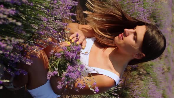 Beautiful Woman Collects a Bouquet in the Lavender Field