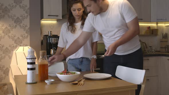 Happy Beautiful Couple Serving Table for Home-cooked Vegetarian Dinner Lifestyle