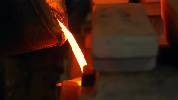 Molten metal being poured in mold at foundry workshop 4k alt