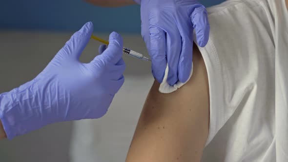 Hands of a Nurse Giving a Vaccine to a Patient alt