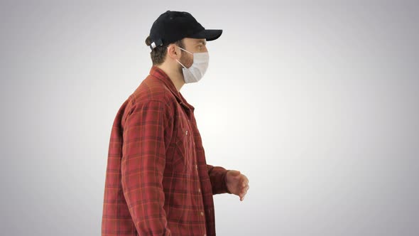 American Farmer in a Cap and Medical Mask Walks Along on Gradient Background. alt