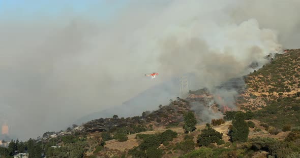 L.A. County Fire Department Helicopter Rushes To the Burning Hollywood Hills. California. USA alt