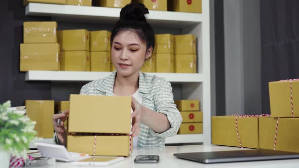 young woman entrepreneur checking parcel boxes in her own job shopping online business at home