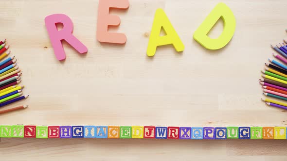 Word READ from multicolor wooden letters on wooden table. alt