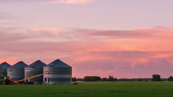 Colorful sunset over farm fields in Idaho looking past grain bins alt