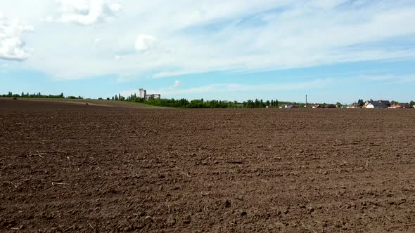Aerial Drone View Flight Over Huge Plowed Field and Blue Sky alt