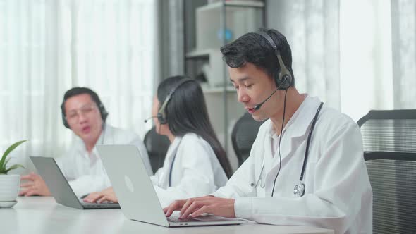 Man Of Three Doctors Working As Call Centre Agents Speaking To Customers While Colleagues Talking alt