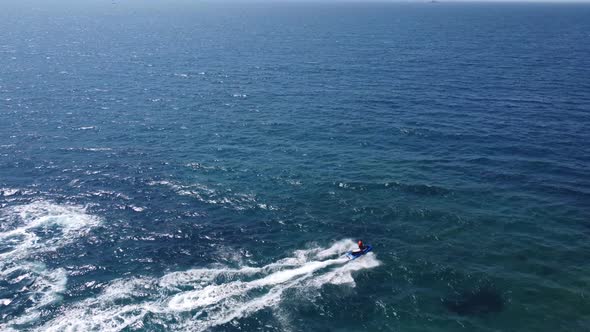 Aerial View Over Man Speeding On Jet Ski Tourist Attraction Exotic Tropical Island Shore Beach At alt