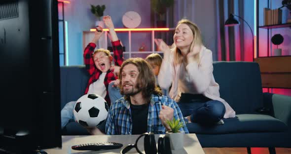 Family Supporting Favourite Football Team at Home and Screaming when Players Scored Goal alt